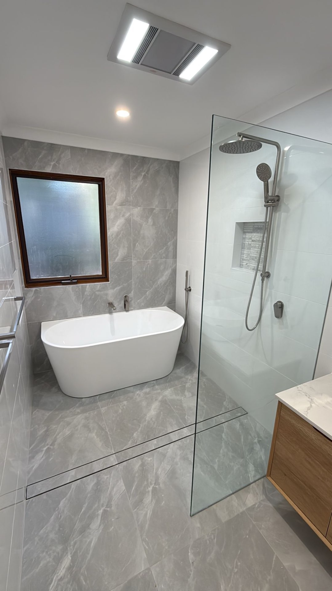 Bathroom renovation completed by Endeavour Plumbing Group — freestanding bath and walk-in shower
